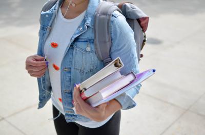 person with jacket and school books